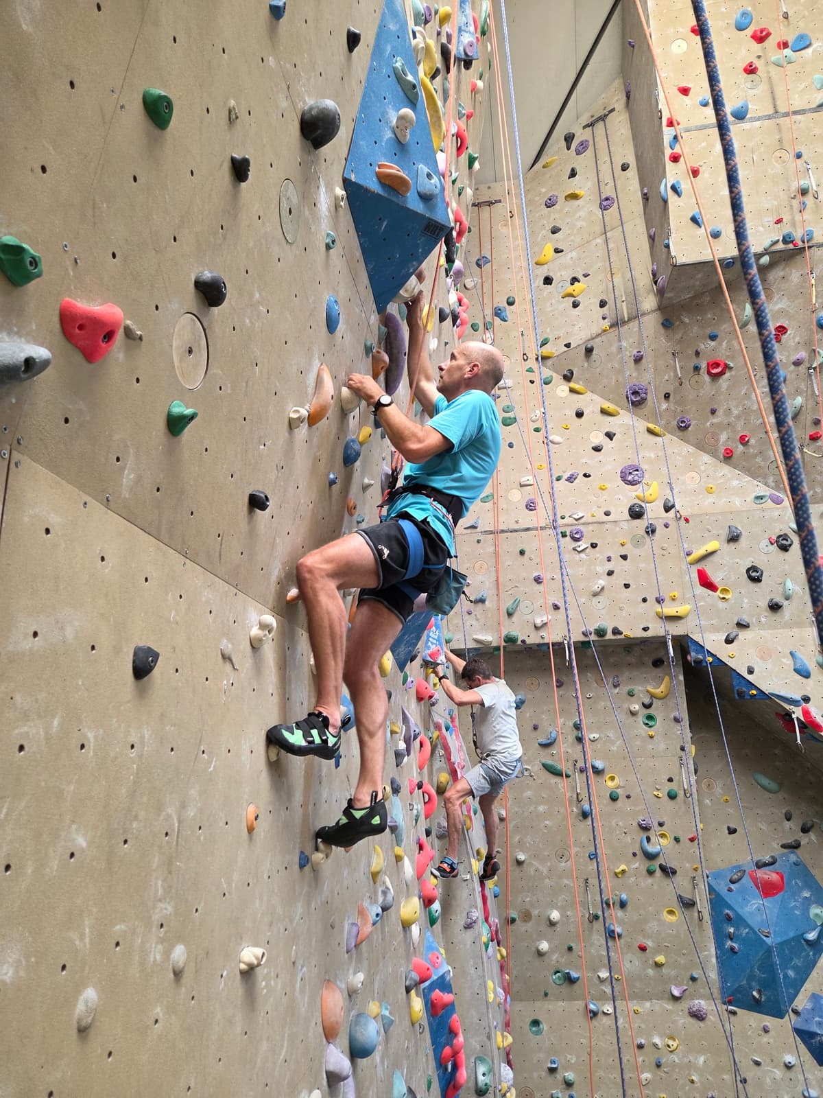 Deelnemers helpen elkaar in de klimhal